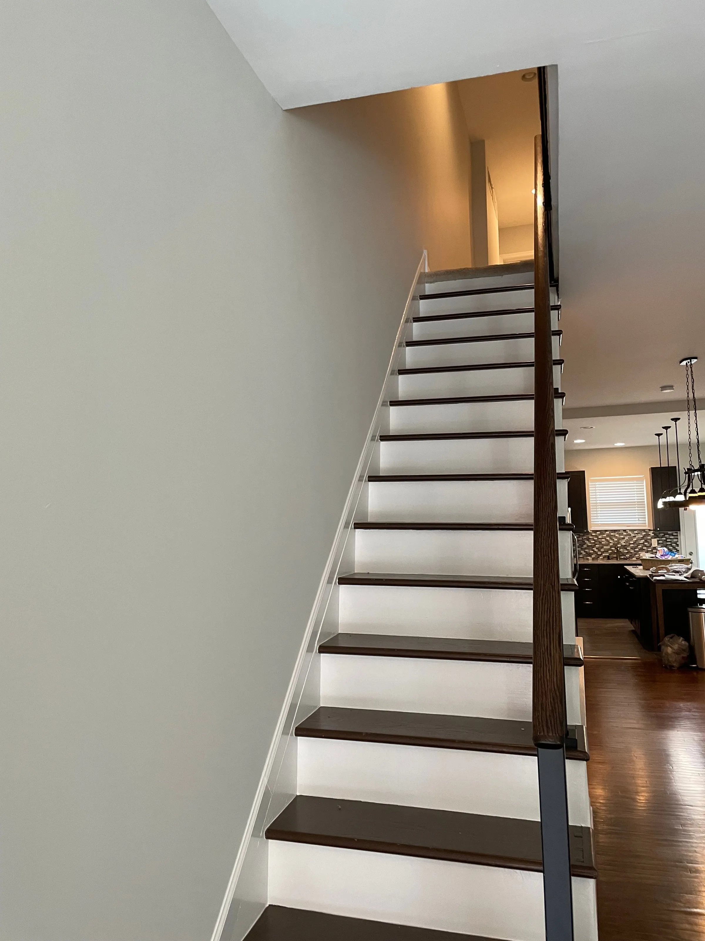 Staircase with white painted balusters and dark treads