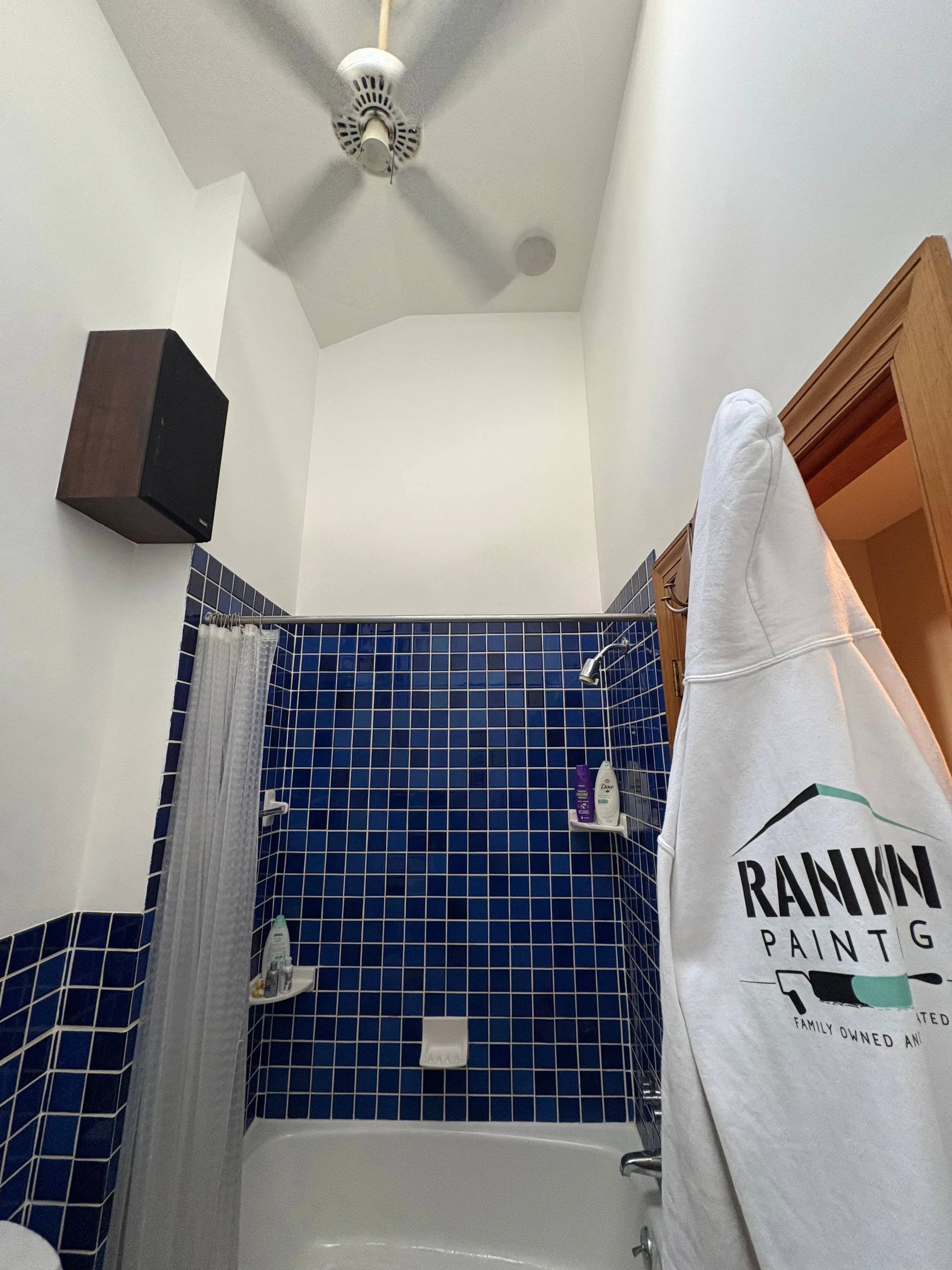 Bathroom with navy tile being painted, Rankin Painting drop cloth protecting the space