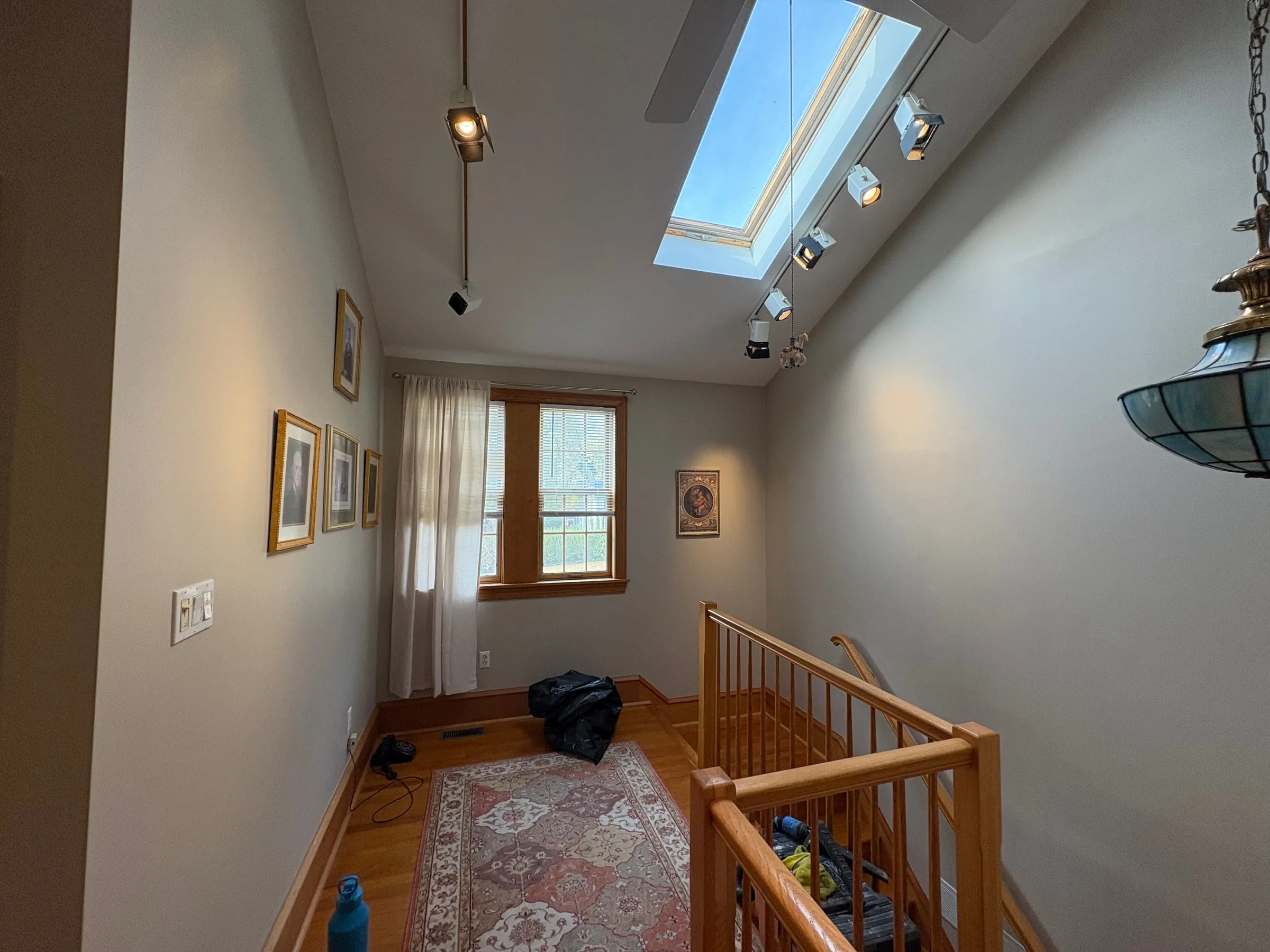 Upstairs landing with skylight and freshly painted walls above hardwood floors