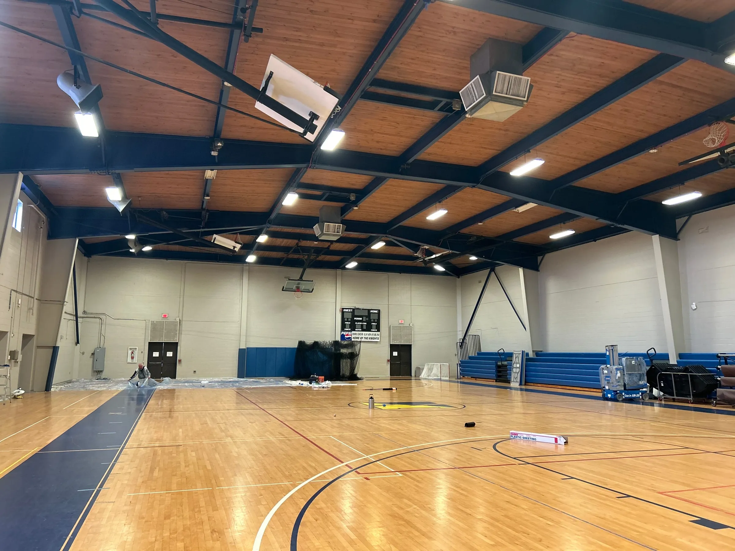 Gymnasium with painted structural steel ceiling above a hardwood court
